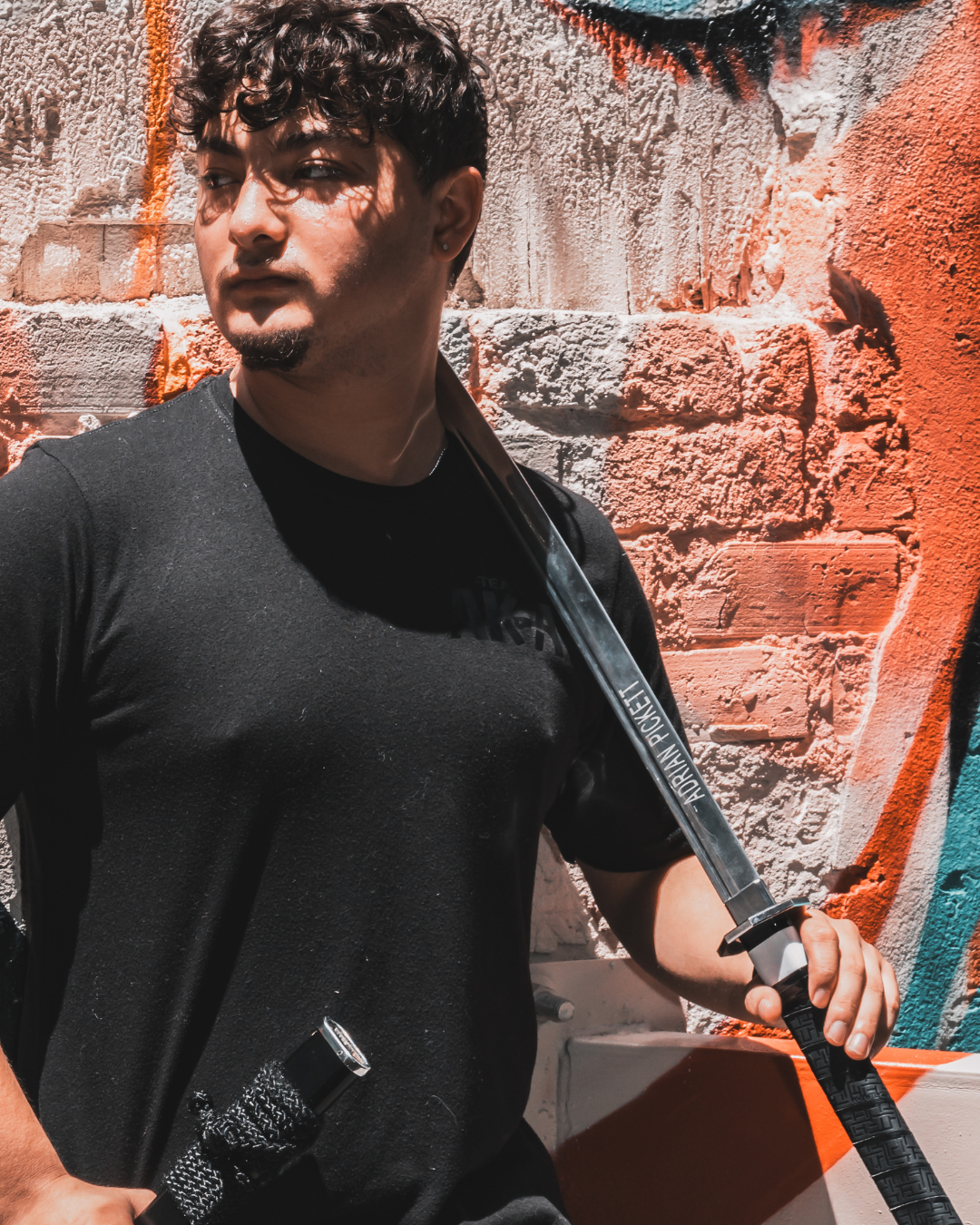 Man holding a sword against a textured wall background
